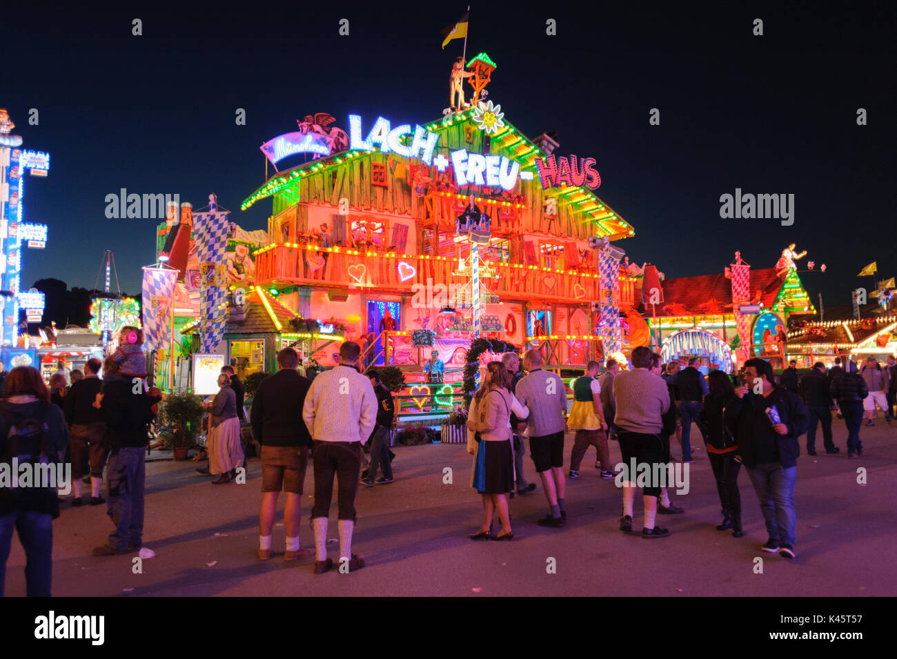 Oktoberfest in Munich is the biggest beer festival of the world with many huge beer tents, carousels, and amusement huts Stock Photo
