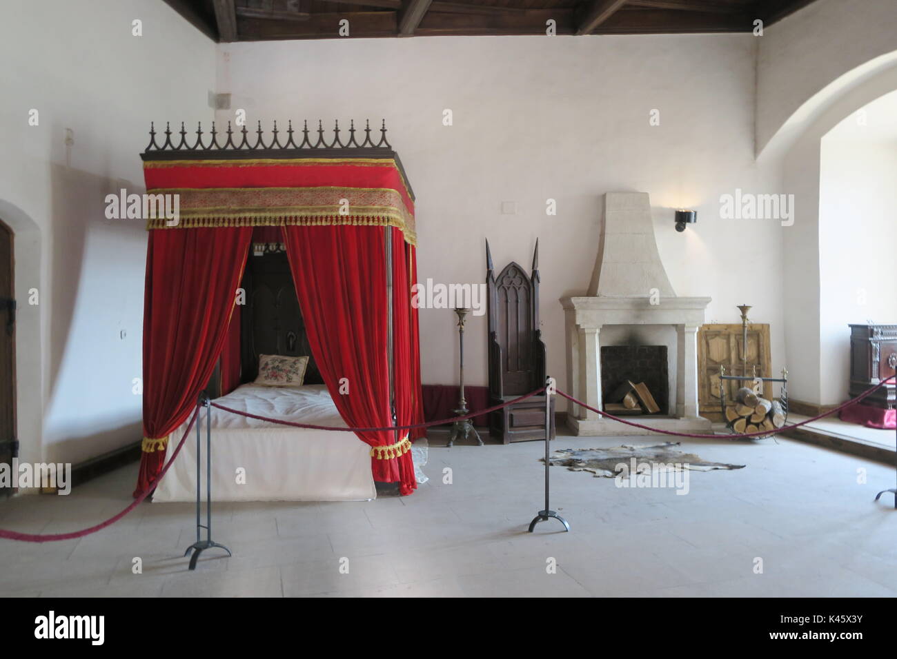 Bed with curtain and fireplace, interior of Corvin castle in Hunedoara,  Romania Stock Photo - Alamy