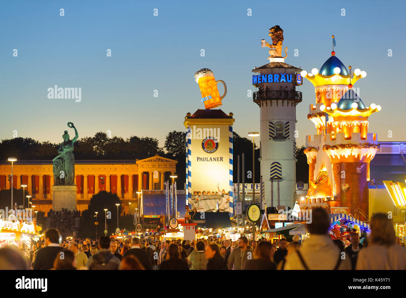 Oktoberfest in Munich is the biggest beer festival of the world with many tourists walking through huge beer tents, carousels, and amusement huts Stock Photo