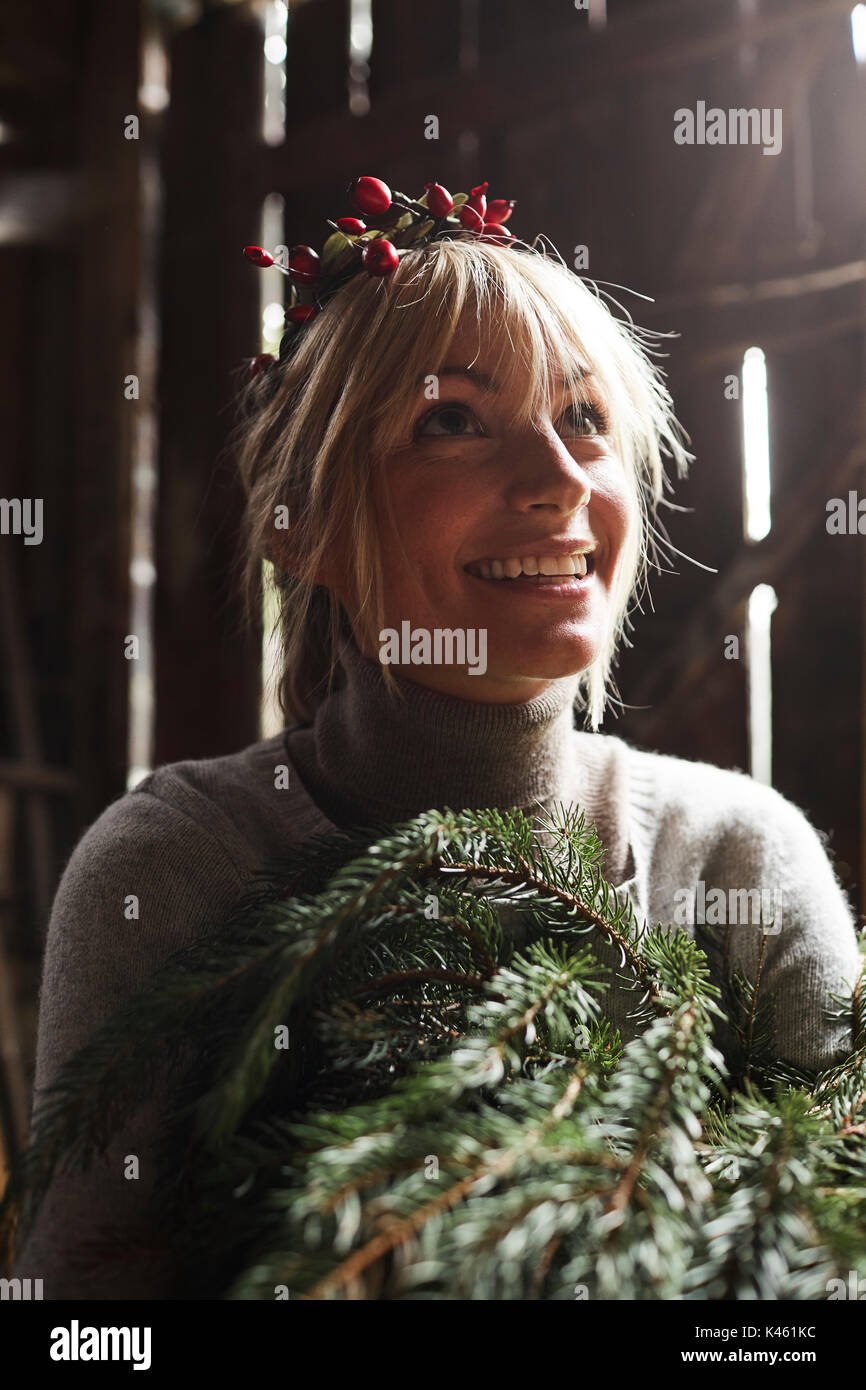 Blond woman, headdress, garland with rose hips, twigs of evergreens for decoration, portrait Stock Photo