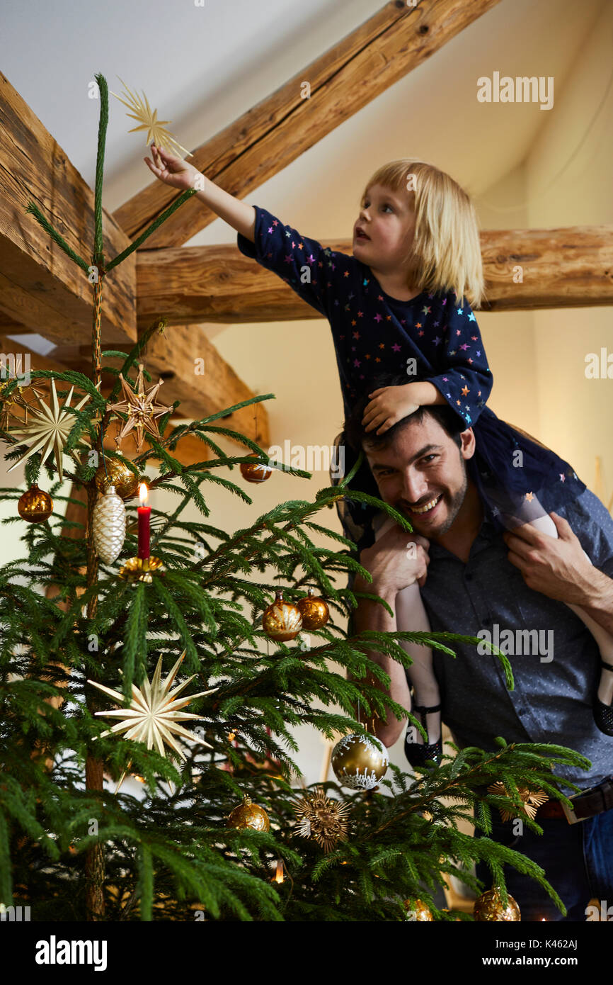 Man and child decorate the Christmas tree Stock Photo