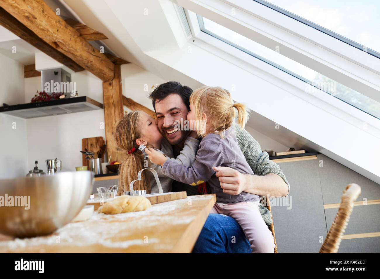 Family baking christmas cookies, father and daughters having fun, kiss on the cheeks, Portrait, Stock Photo