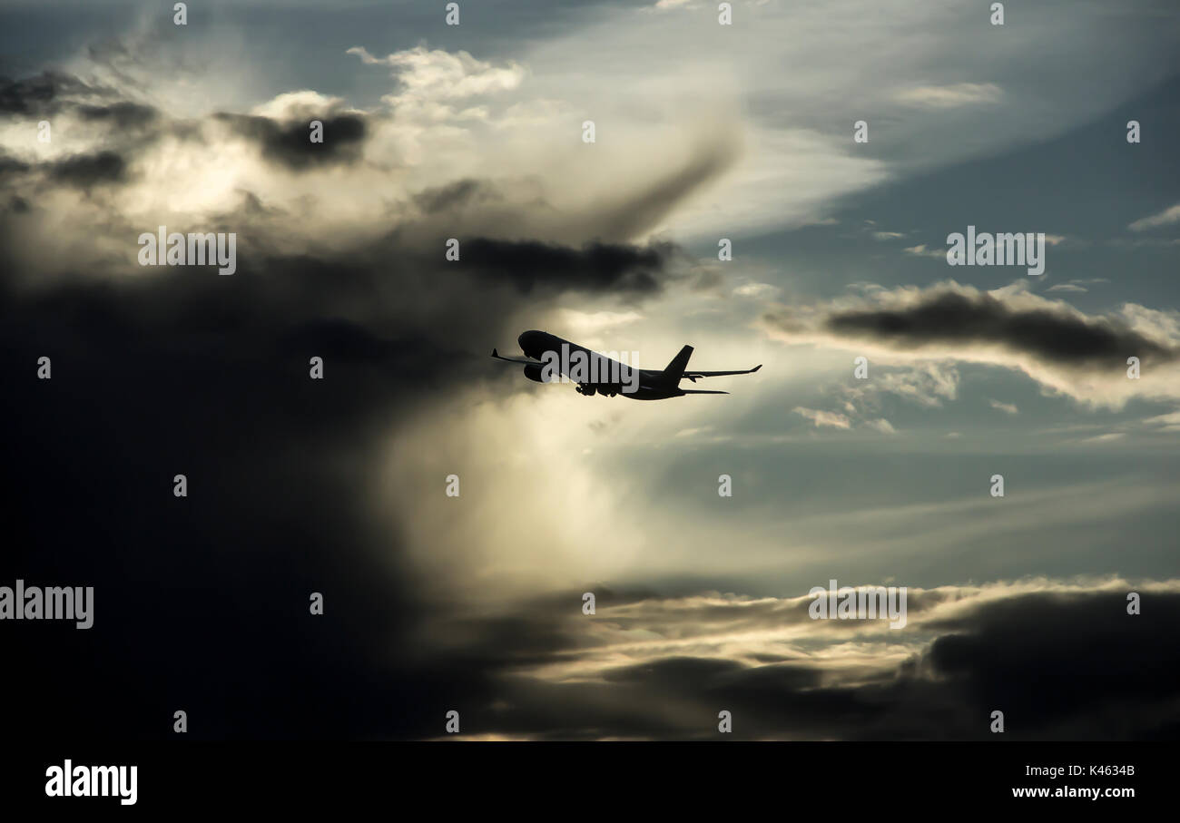 outline of an airplane flying into thunderstorm cloud Stock Photo