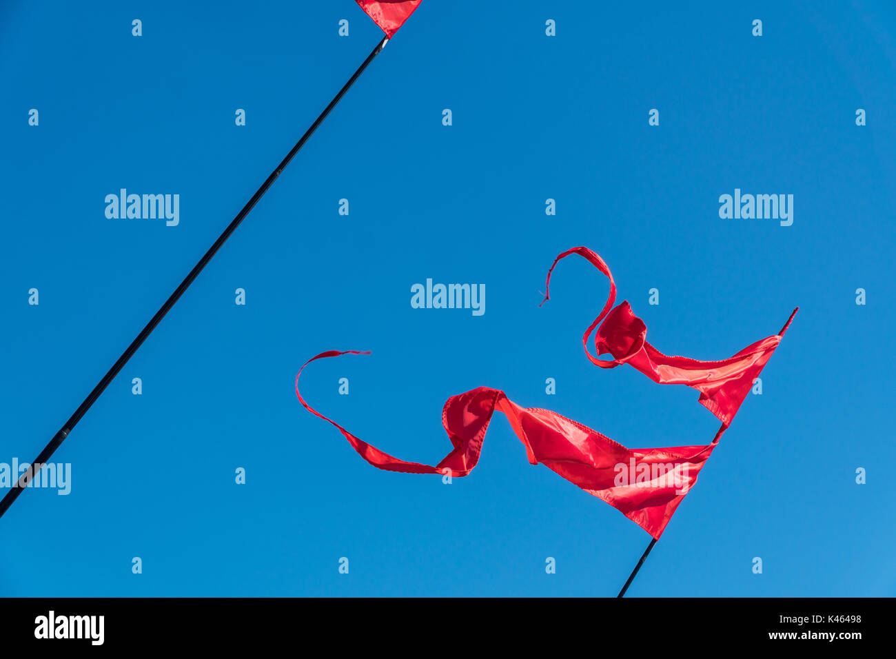 Red flags are fluttering in the wind against the blue sky Stock Photo ...