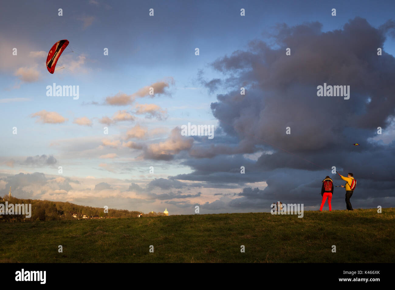 Two Londoners fly their kite on a windy, stormy, sunny day on Hampstead
