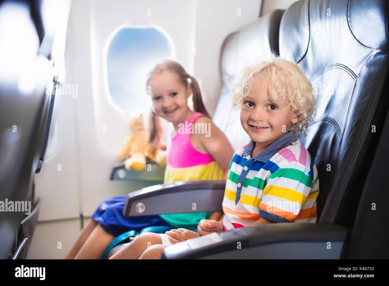 Child in airplane. Kids sit in air plane window seat. Flight