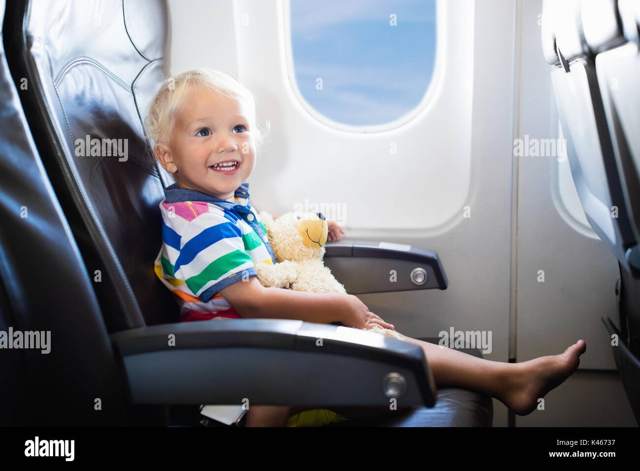 Child in airplane. Kid in air plane sitting in window seat. Flight ... Child in airplane. Kid in air plane sitting in window seat. Flight ...