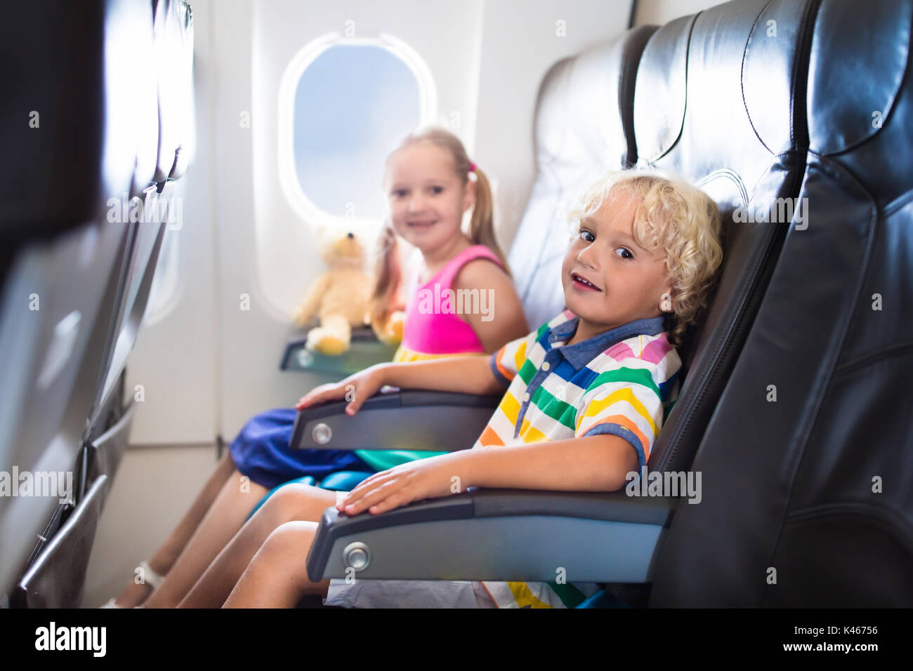 Child in airplane. Kids sit in air plane window seat. Flight