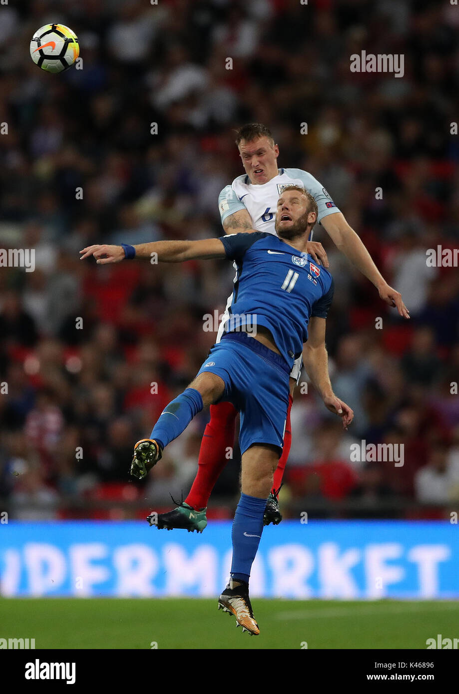 England's Phil Jones (top) and Slovakia's Adam Nemec battle for the ball during the 2018 FIFA World Cup Qualifying, Group F match at Wembley Stadium, London. Stock Photo