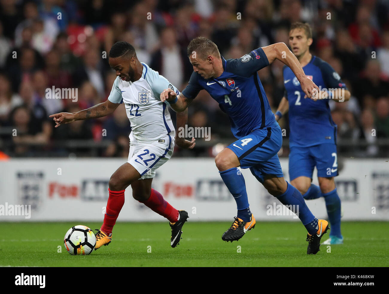 England's Raheem Sterling and Slovakia's Jan Durica battle for the ball during the 2018 FIFA World Cup Qualifying, Group F match at Wembley Stadium, London. Stock Photo