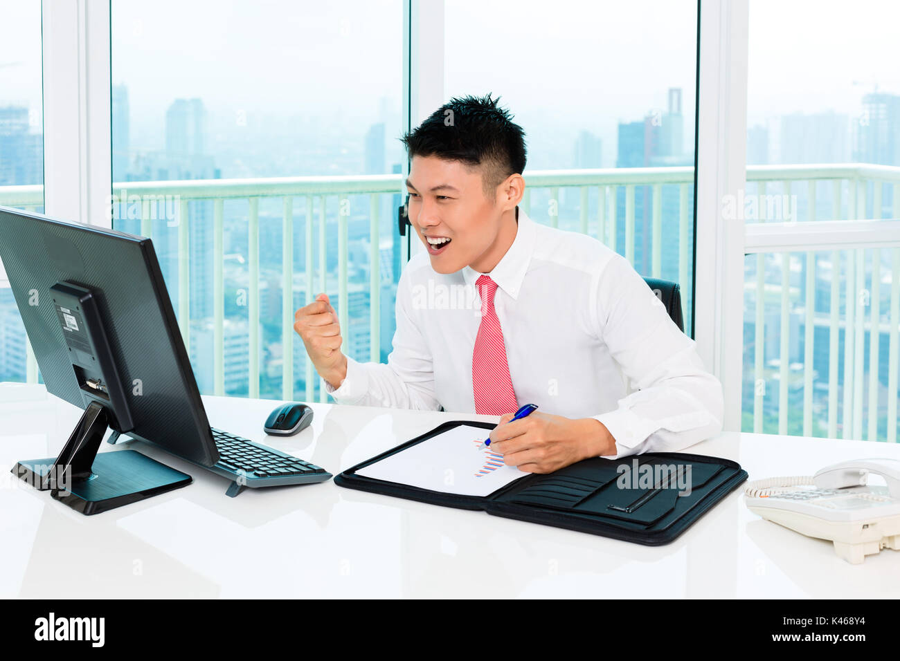 Asian broker trading at stock exchange in office making profit Stock Photo