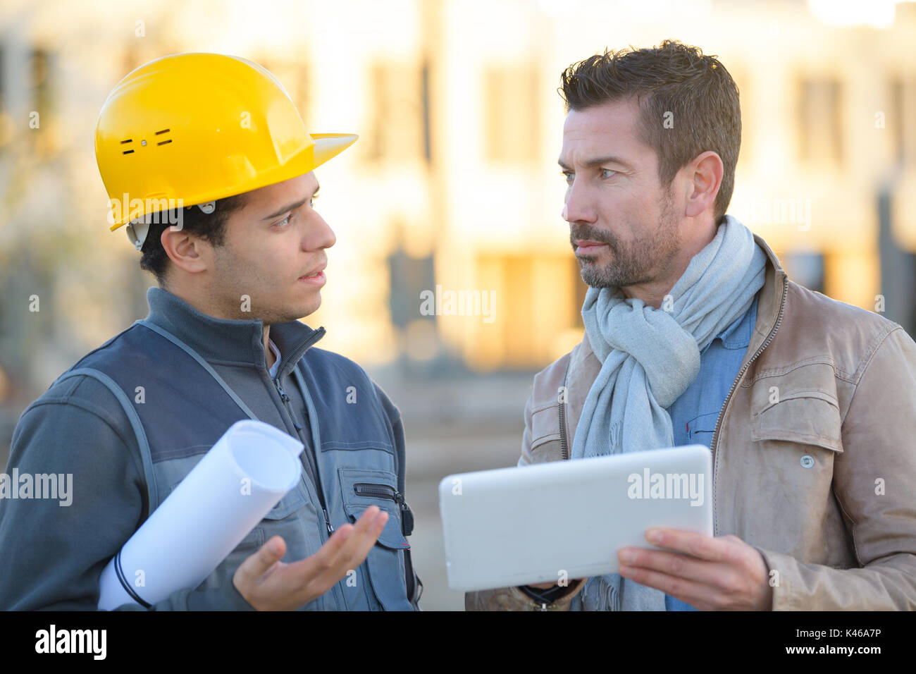 engineer with hard hat using tablet talking to supervisor Stock Photo