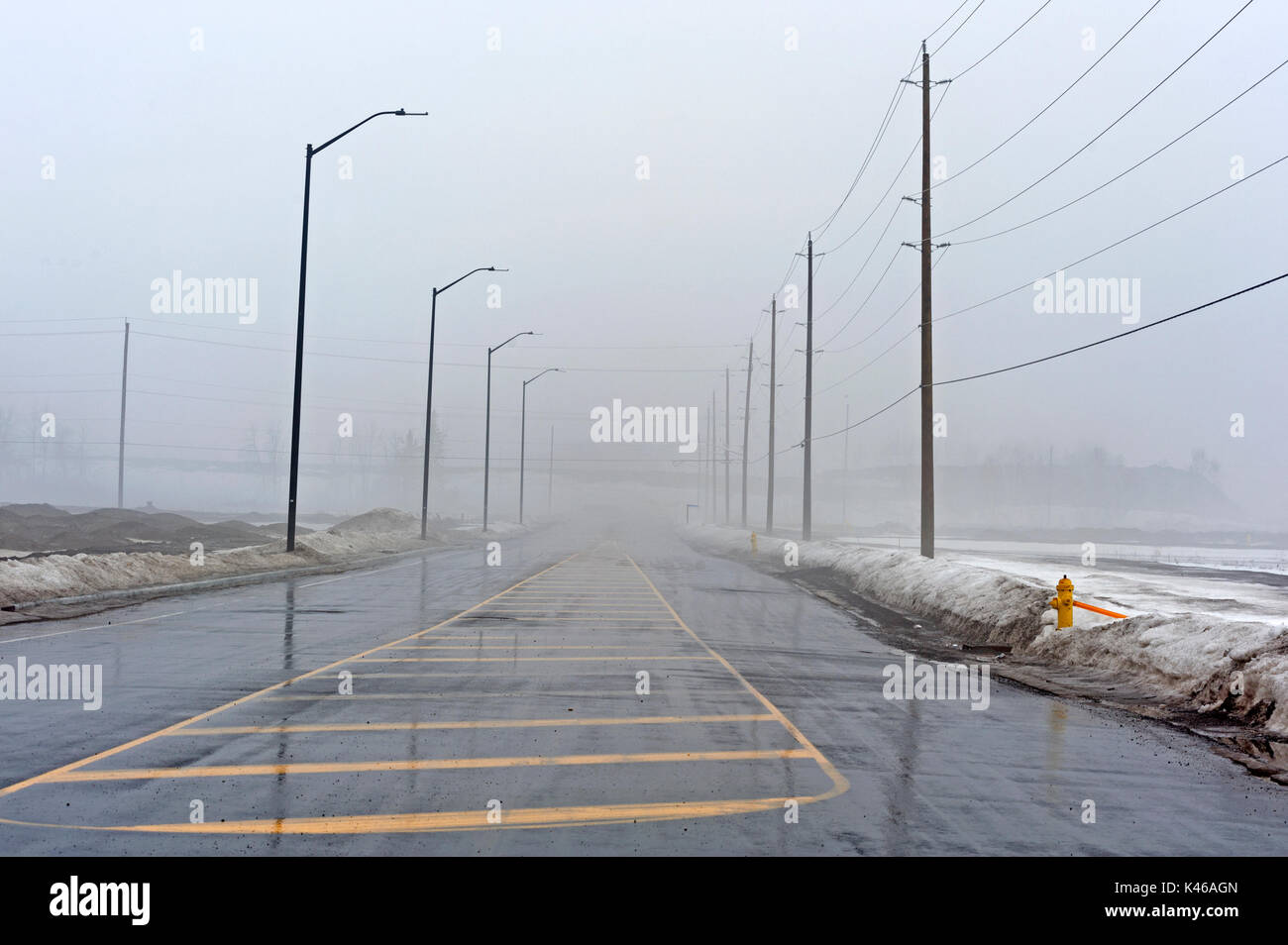 Wet steet disappears into thick fog Stock Photo