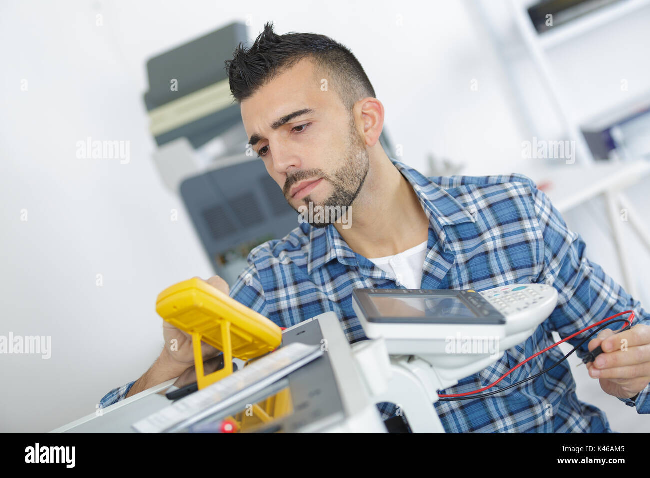 high angle view of technician checking machine with digital multimeter Stock Photo