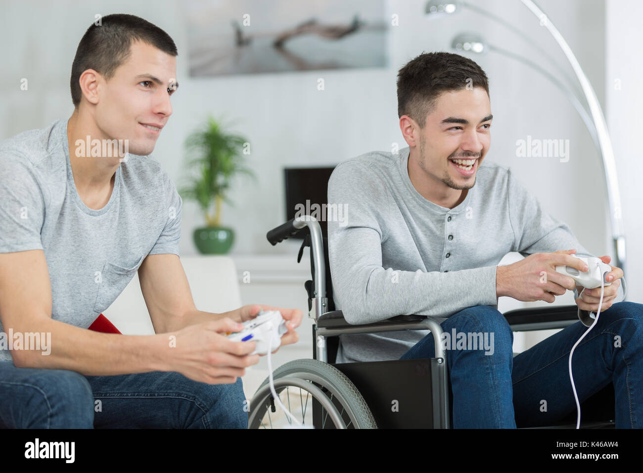 friend and boy in wheelchair playing videogames Stock Photo Alamy