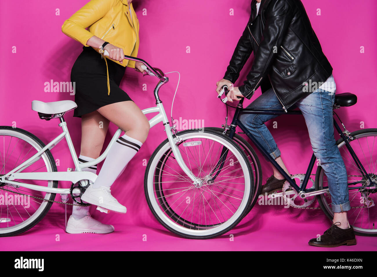 Cropped shot of stylish elderly couple in leather jackets riding bicycles together Stock Photo