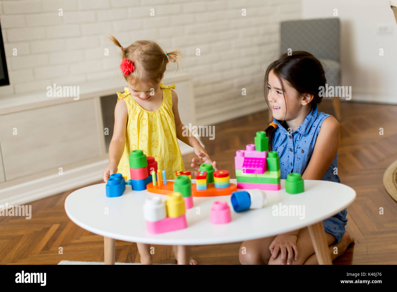 Two little girls playing with toys in the room at home Stock Photo - Alamy