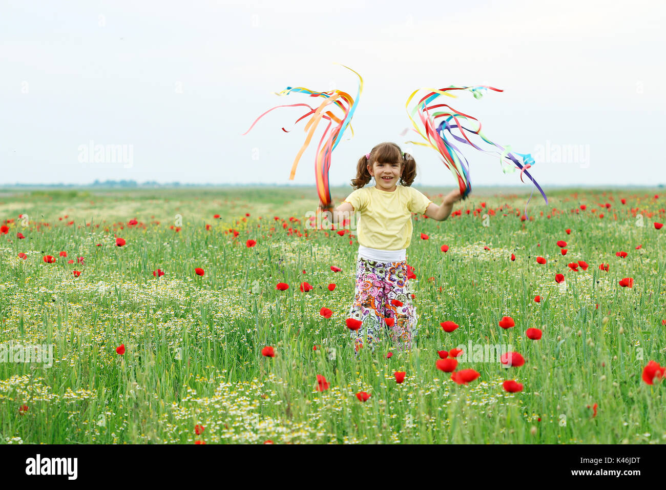 happy little girl playing on meadow spring season Stock Photo - Alamy