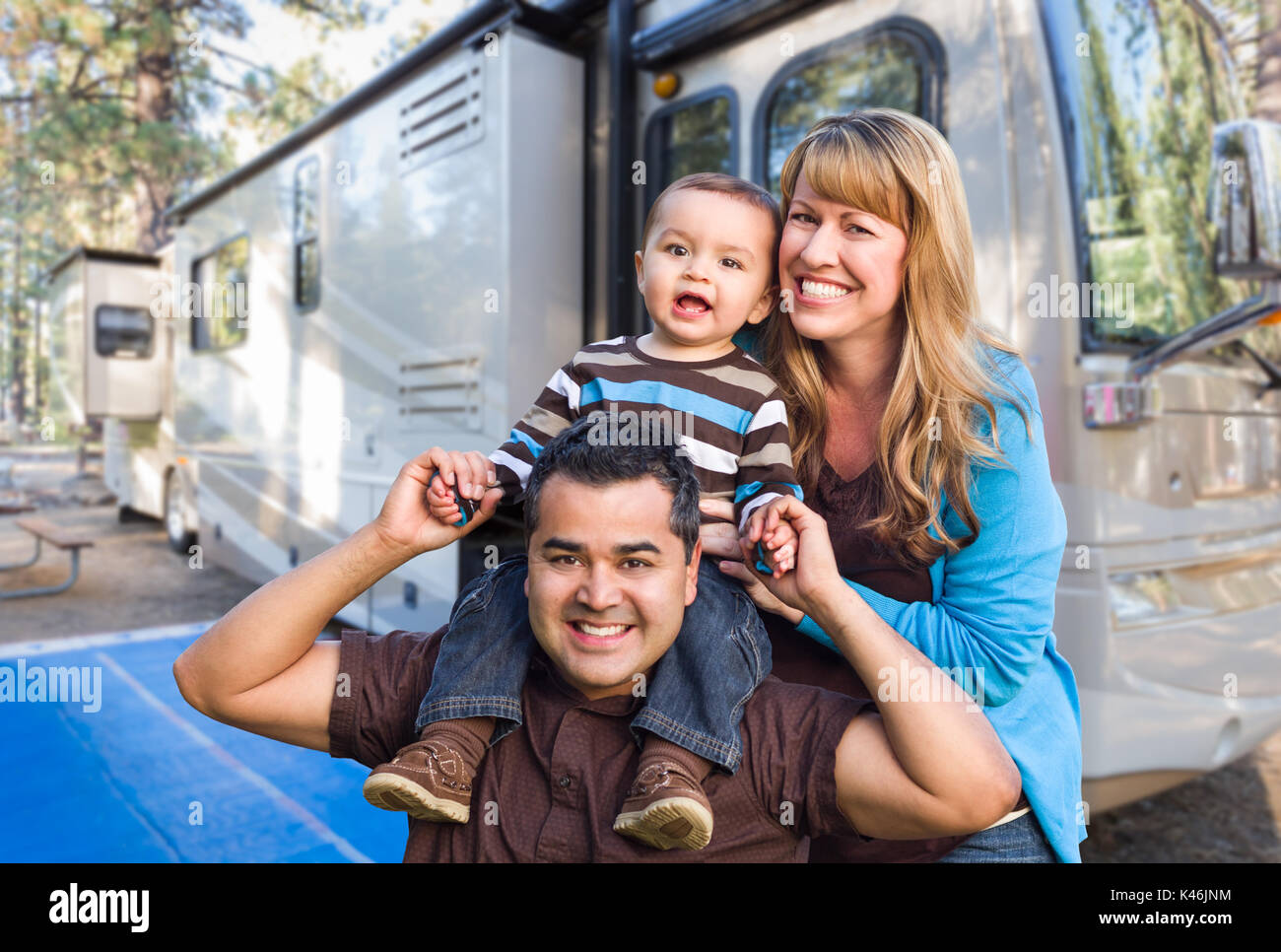 Happy Young Mixed Race Family In Front of Their Beautiful RV At The Campground. Stock Photo