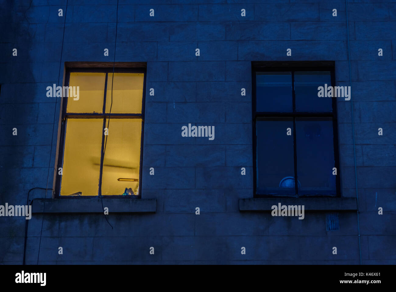 Two Light Window Two windows, one of which is illuminated, on the facade of a building ...