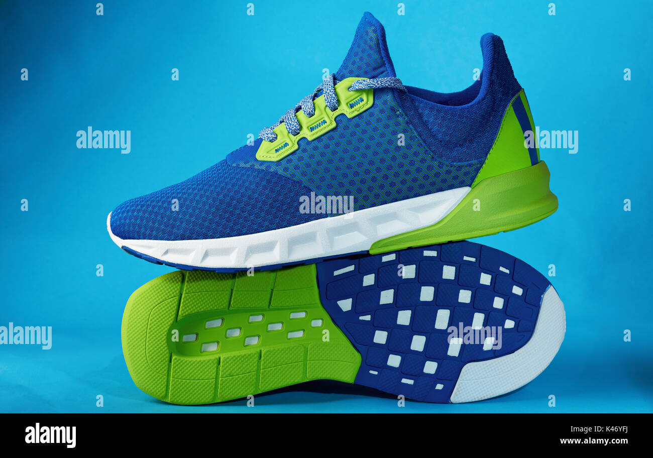 Modern colorful sneaker pair shoes isolated on blue background. New training shoes Stock Photo