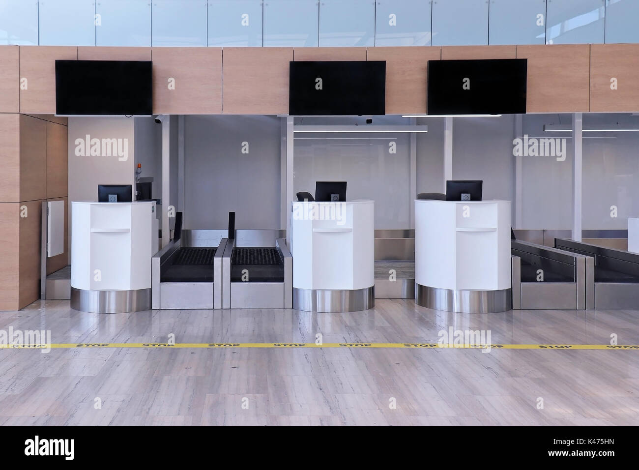 Empty airport check in counter with luggage conveyers Stock Photo