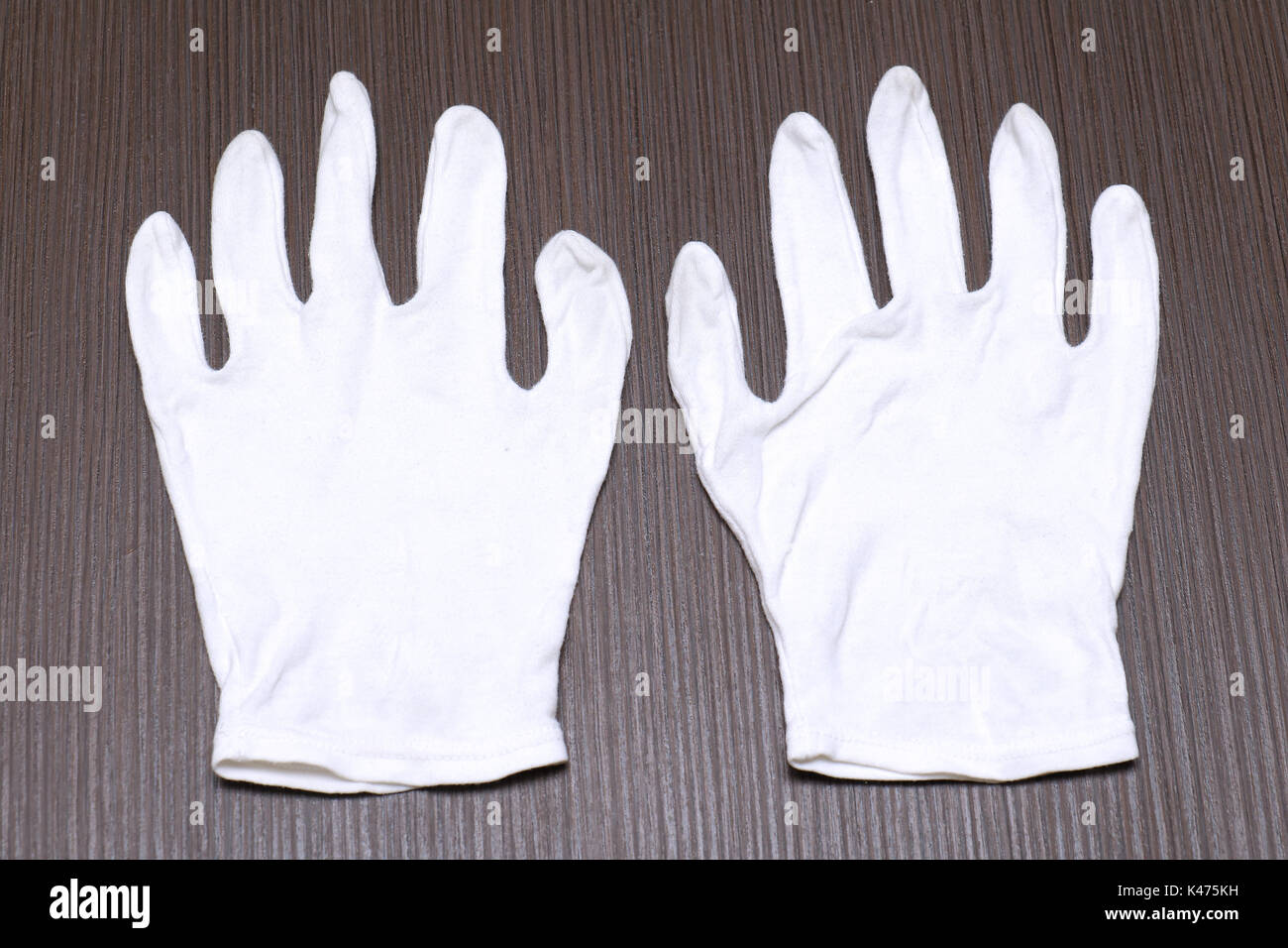 White cotton gloves on wooden background Stock Photo - Alamy