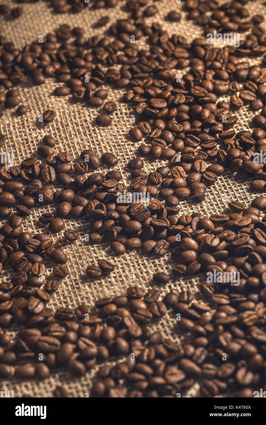 Roasted coffee beans on the fabric of the coffee bag. Stock Photo