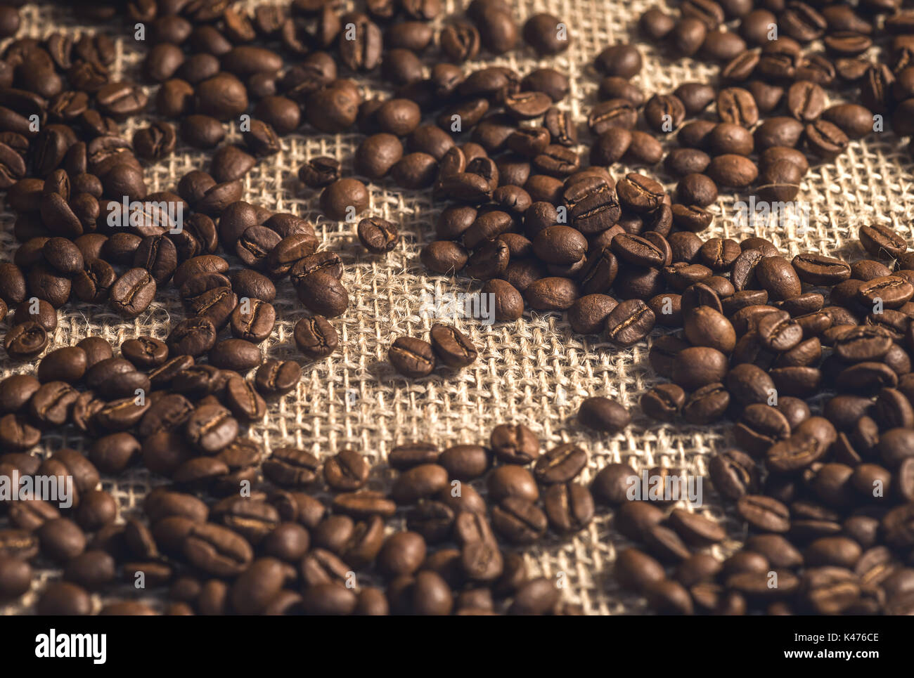 Roasted coffee beans on the fabric of the coffee bag. Stock Photo