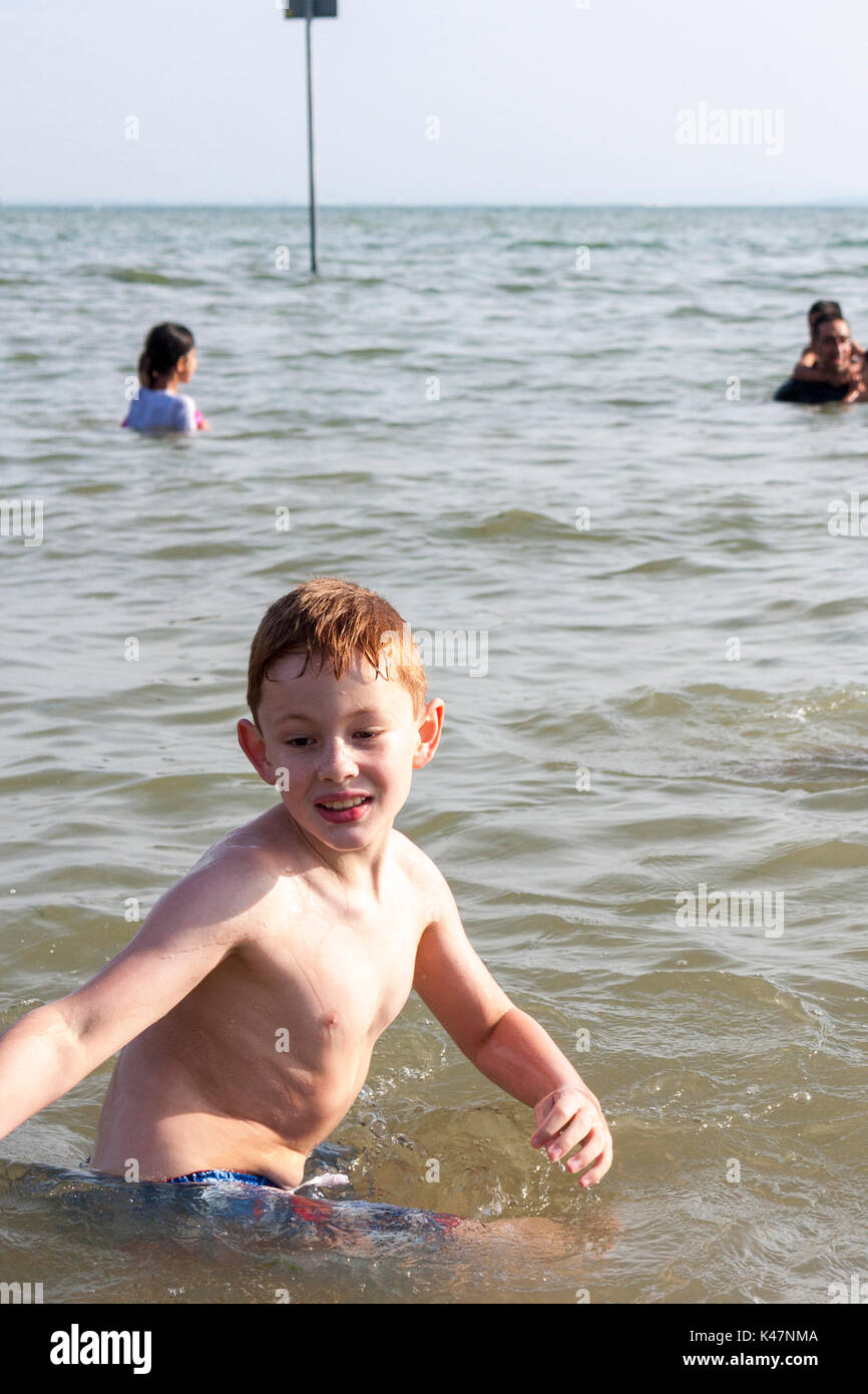 An eight year old boy playing in the sea at SouthendonSea, Essex, UK