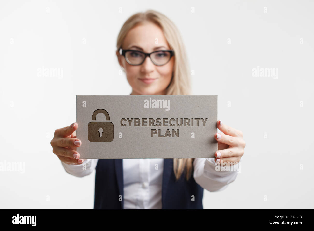 Business, Technology, Internet and network concept. Young woman holding a sign with an inscription CYBERSECURITY PLAN. Stock Photo