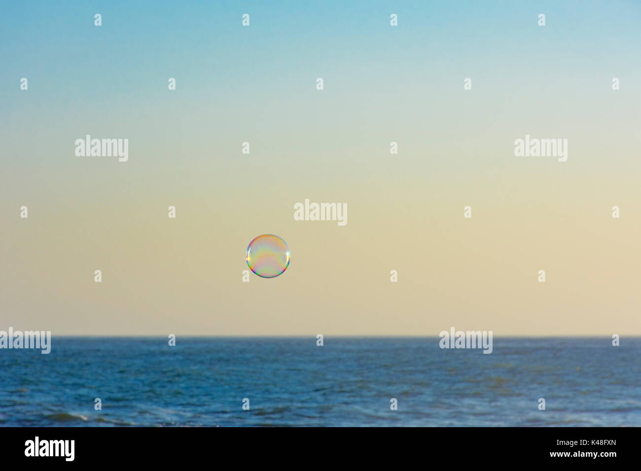 Soap bubble floating over the ocean Stock Photo - Alamy