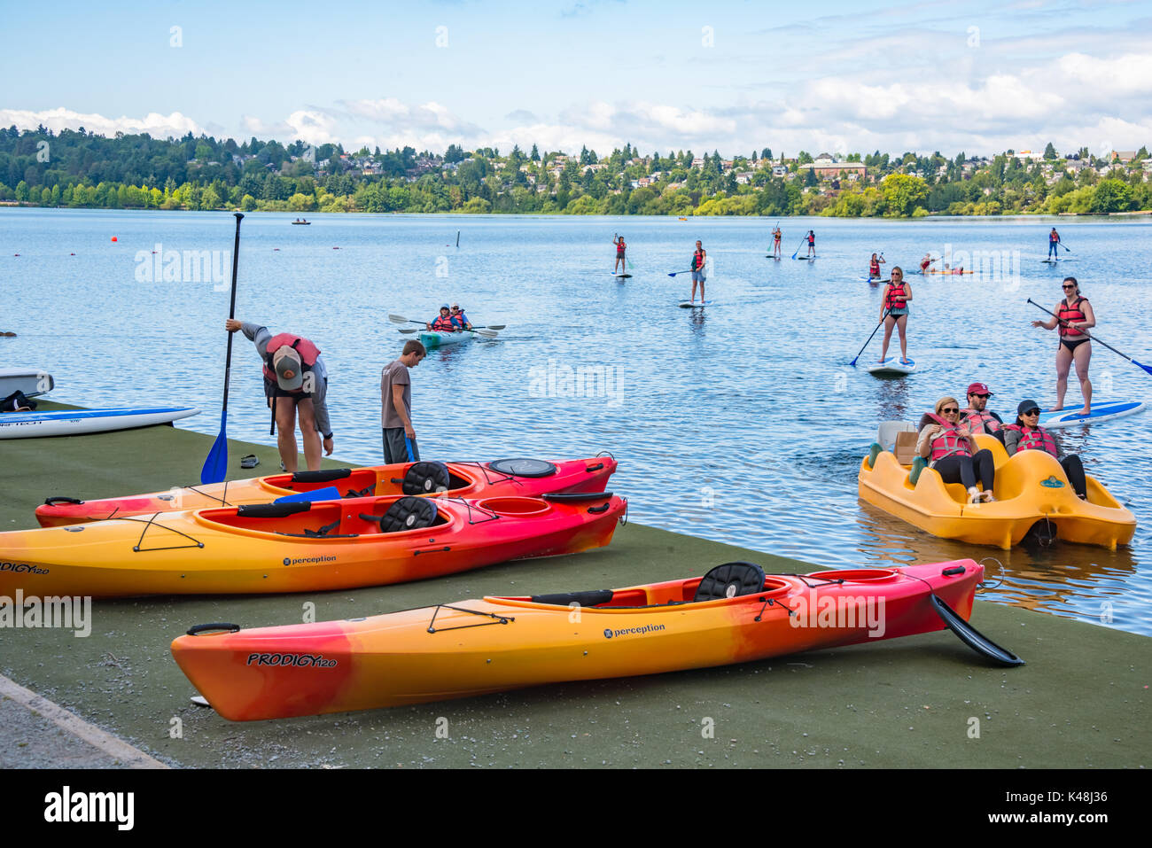 Family Boating and Stand Up Paddle Boarding at Green Lake City Park Seattle Washington Stock Photo