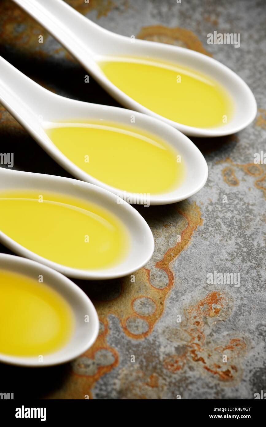 Olive oil in a small china spoons Stock Photo Alamy
