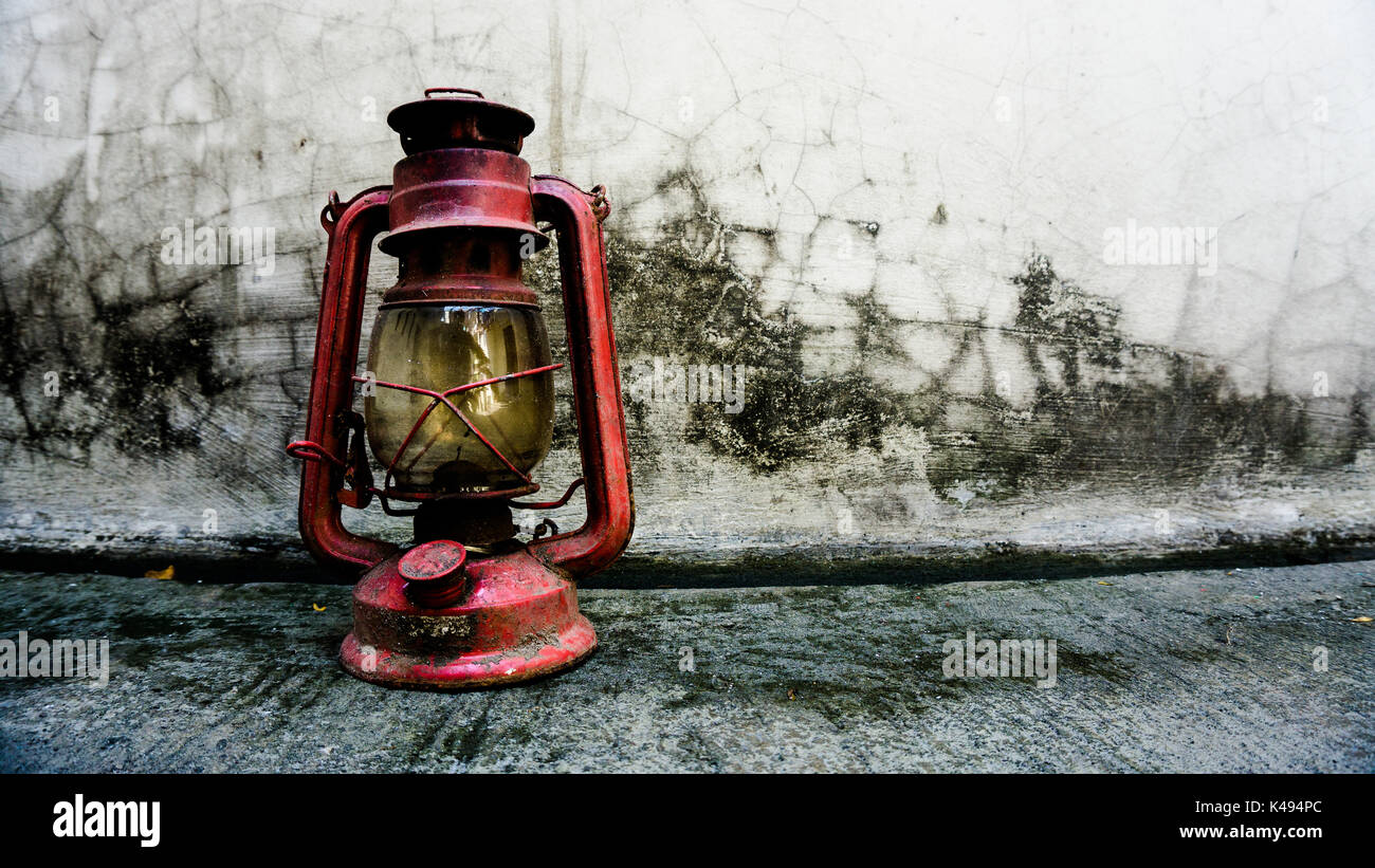 An old classic lantern laid around on the ground being left by the owner after going back from camping Stock Photo