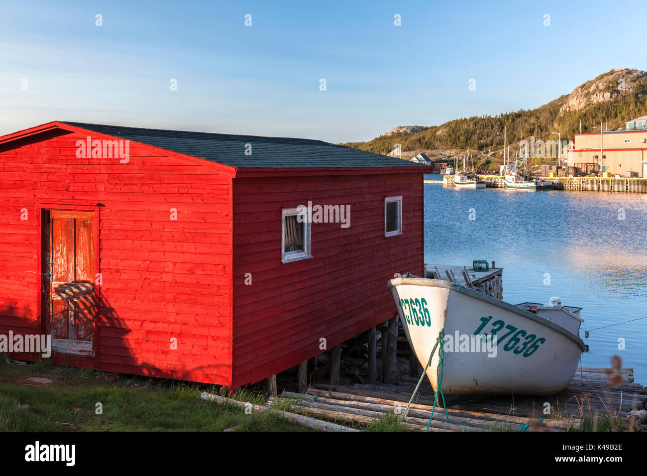 A small fishing boat and a red boathouse in Salvage in Newfoundland and Labrador, Canada. Stock Photo
