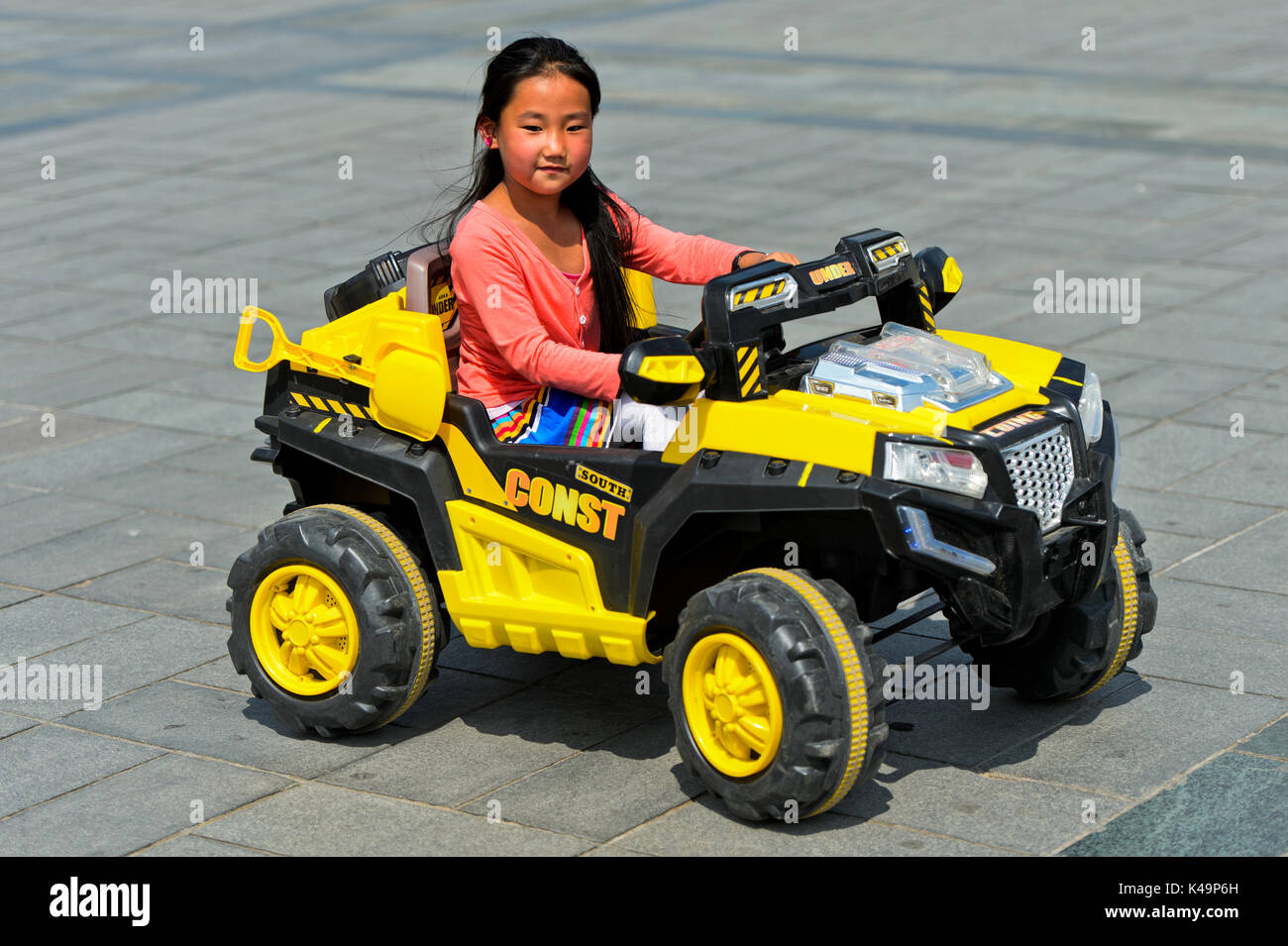 Young Girl Riding An Electric Toy Car, Ulaanbaatar, Mongolias Stock Photo