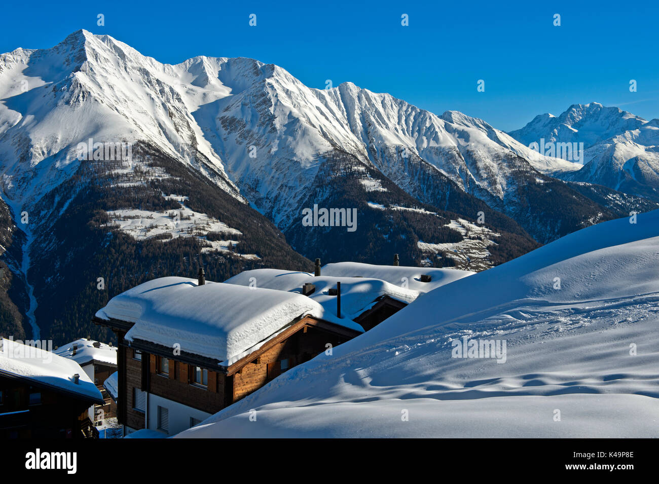 Snow-Covered Mountain Peaks And Chalets During Winter In The Mountain Village Bettmeralp, Valais, Switzerland Stock Photo