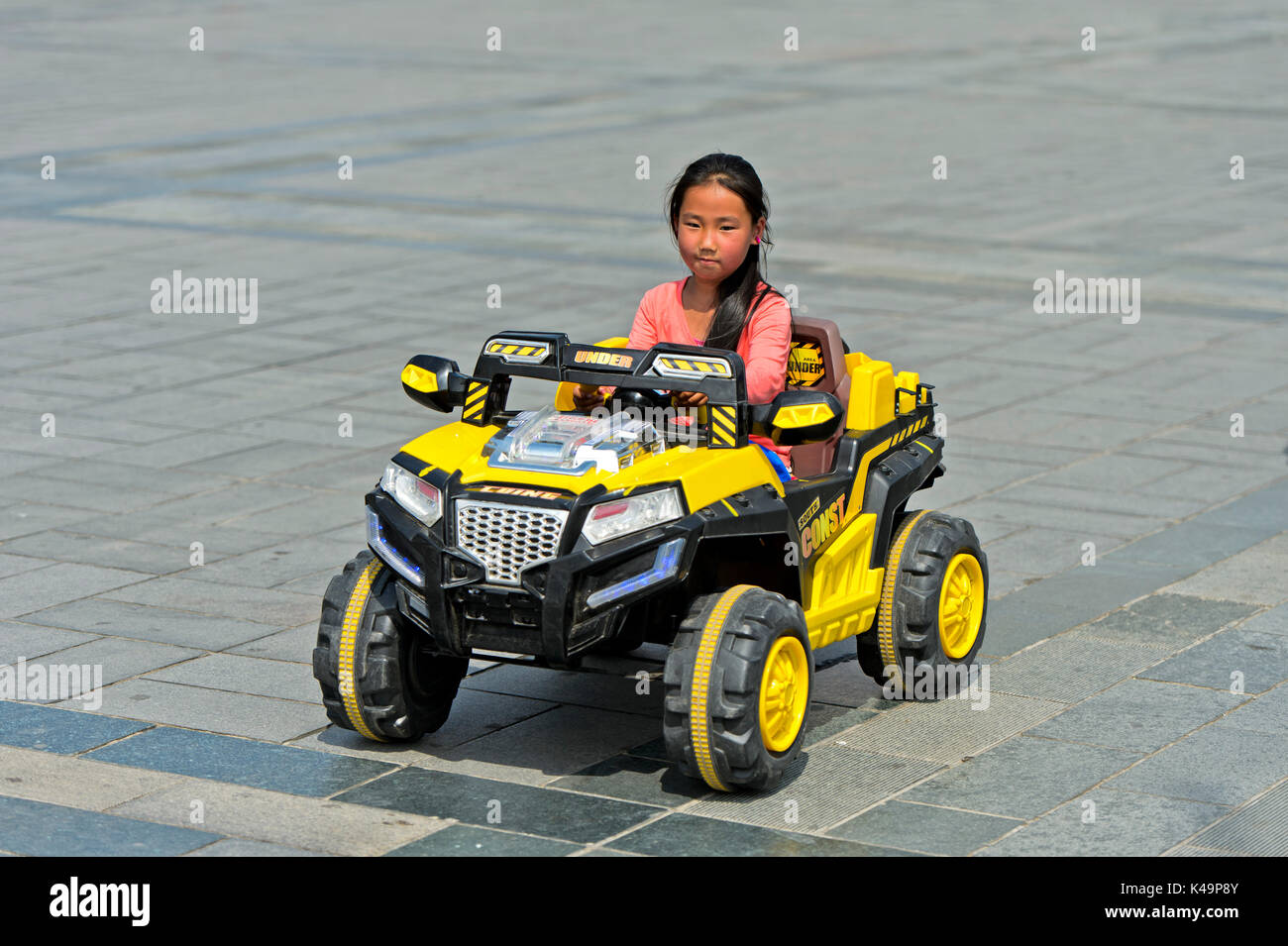 Girl Riding An Electric Toy Car, Ulaanbaatar, Mongolia Stock Photo