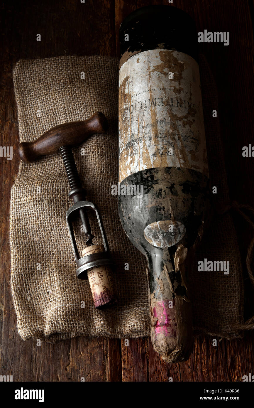 Old Corkscrew With Red Wine Bottle On Wooden Background Stock Photo