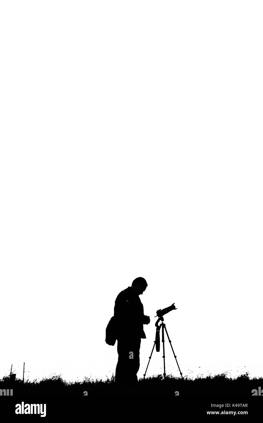 Photographer with Camera on Tripod in Silhouette Stock Photo