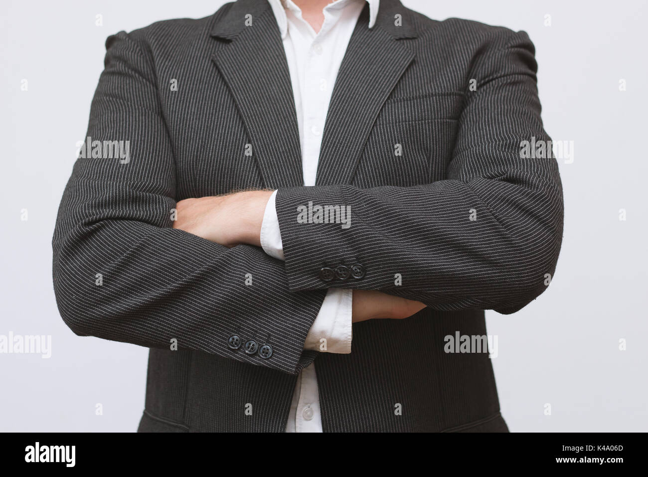 Mann im Anzug mit verschraenkten Armen Stock Photo