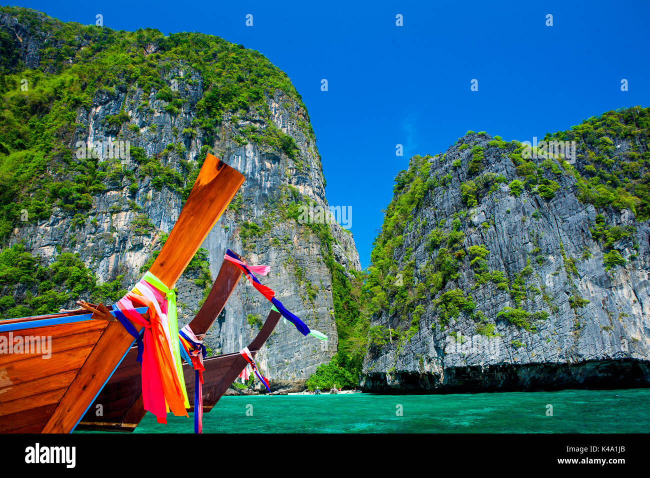 Thailand beach seascape with ring of steep limestone hills and traditional bright longtail boats parking, Maya Bay, Ko Phi Phi Lee island, Phi Phi arc Stock Photo