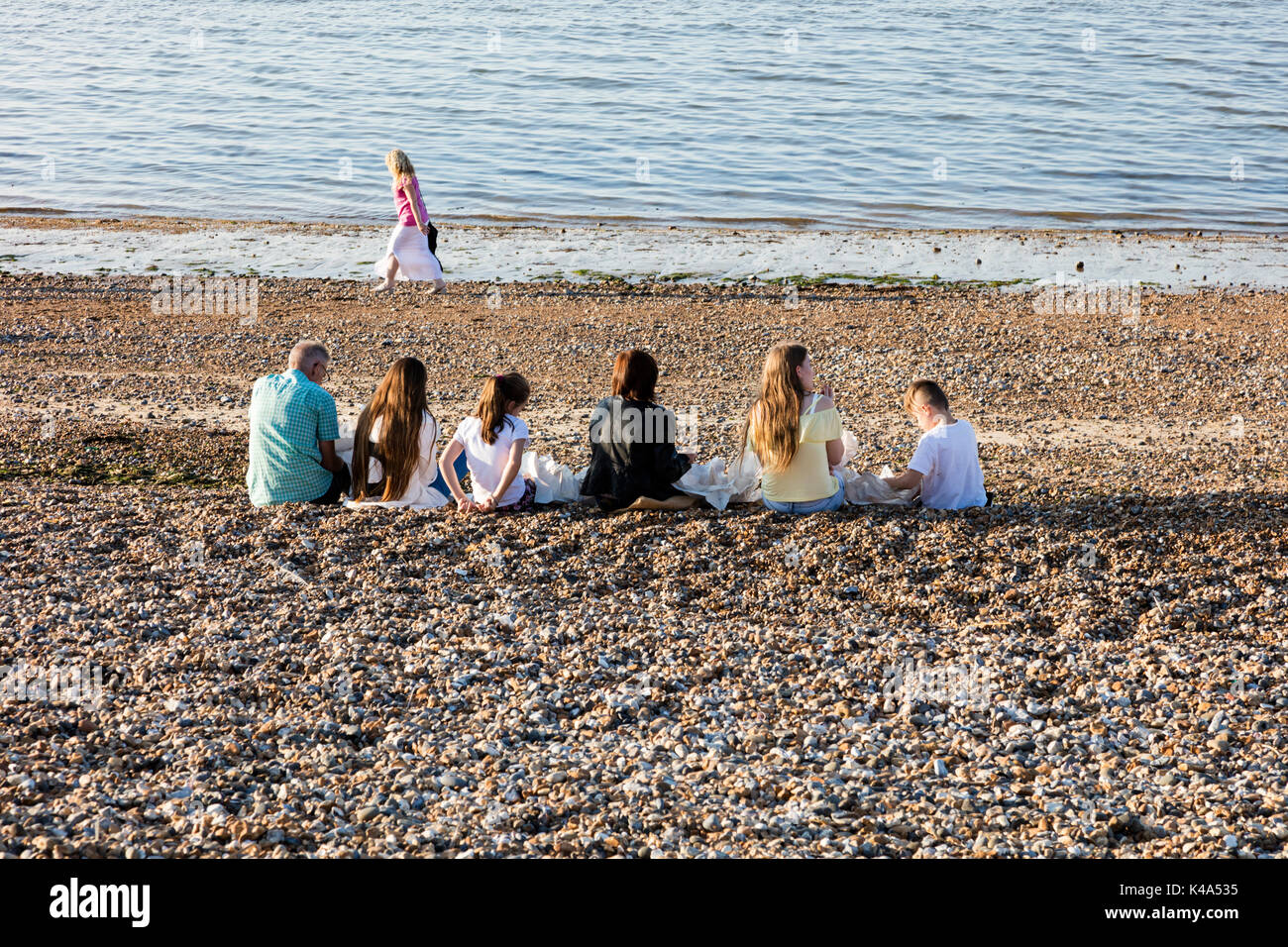 Holiday makers eat fish and chips on the beach in Herne Bay at the end of the summer, Kent, UK