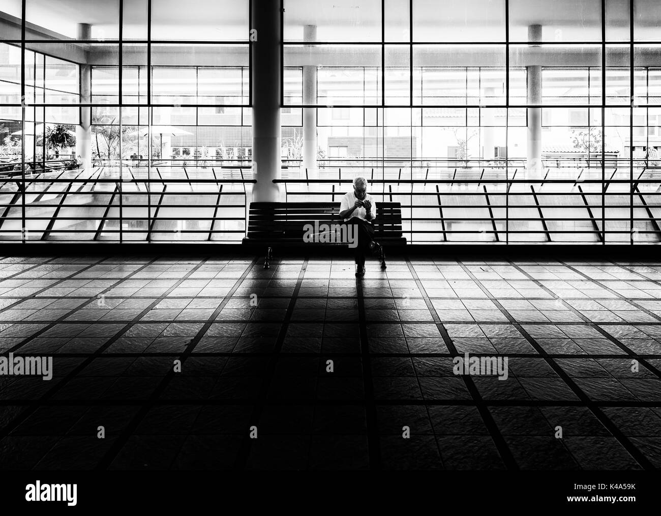 Senior Sitting On A Wooden Bench In A Market Hall Stock Photo