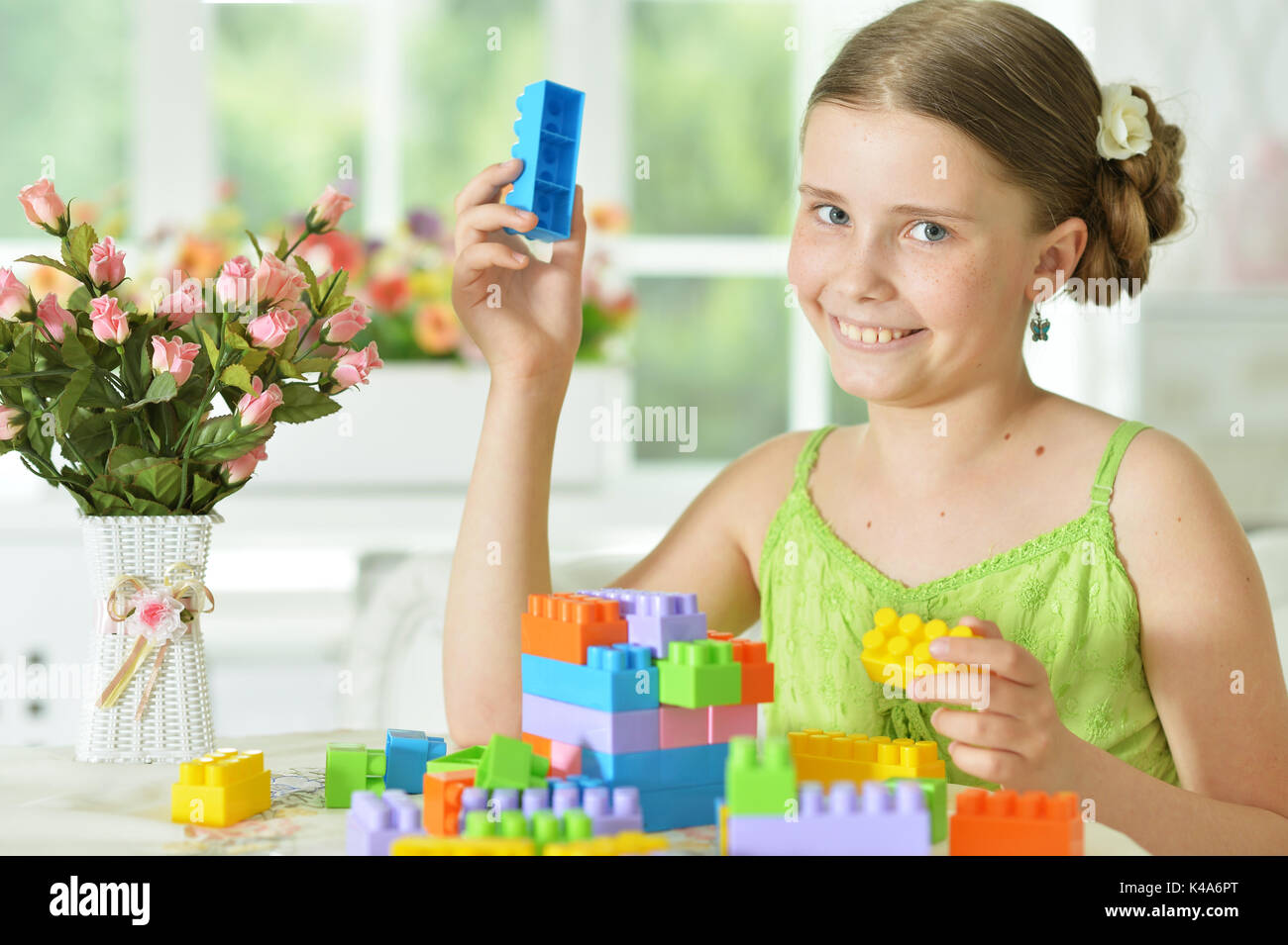 Cute girl playing with plastic blocks Stock Photo - Alamy