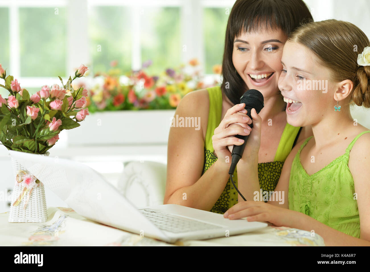 mother and daughter singing karaoke Stock Photo Alamy