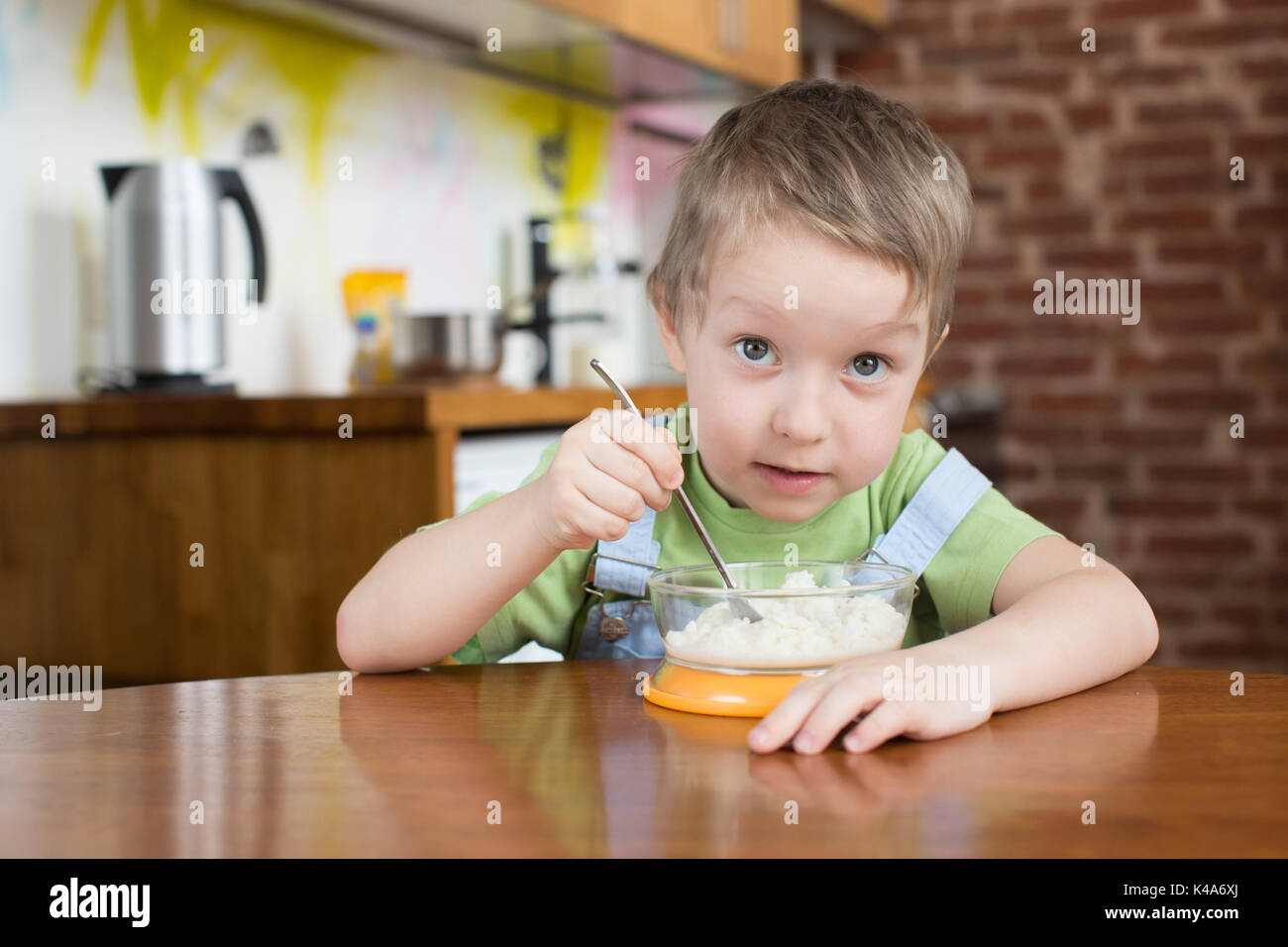 Five years boy opened his mouth porridge kitchen Stock Photo
