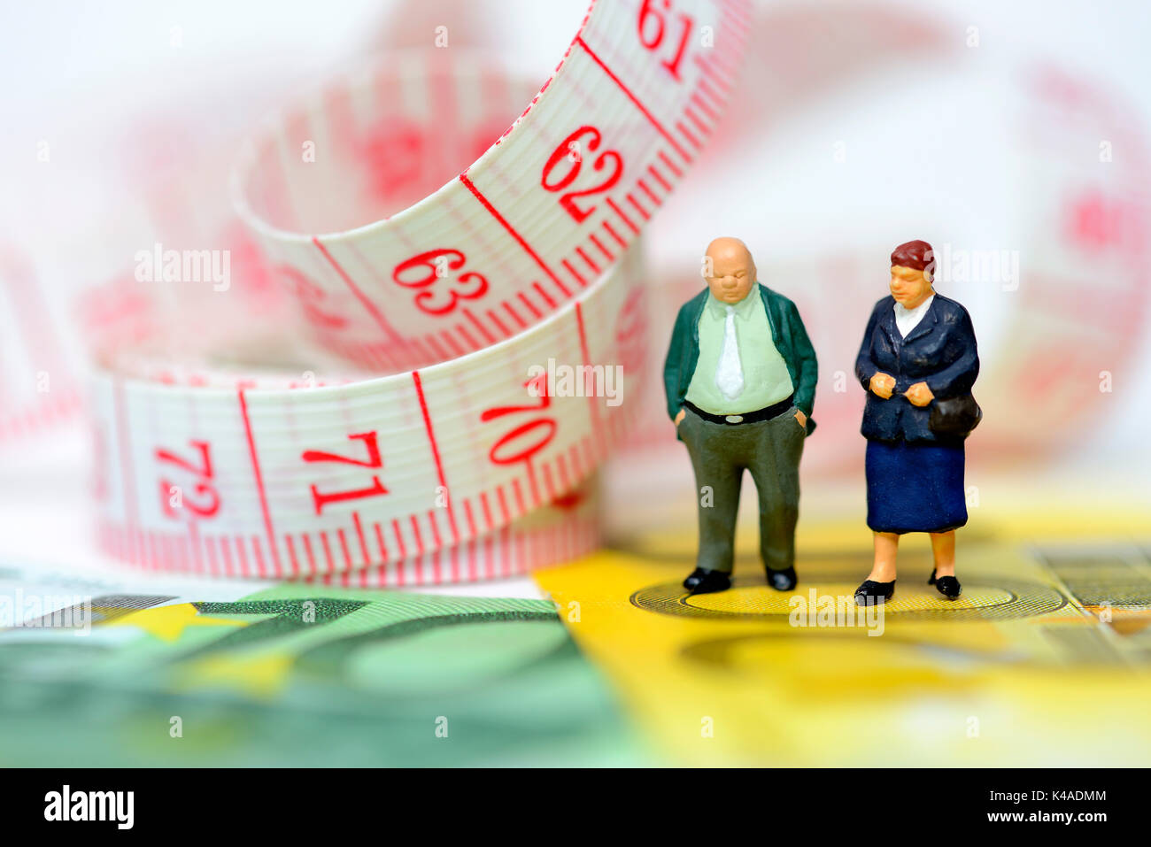 Old Couple Miniatures, Euro Banknotes And Measuring Tape Stock Photo