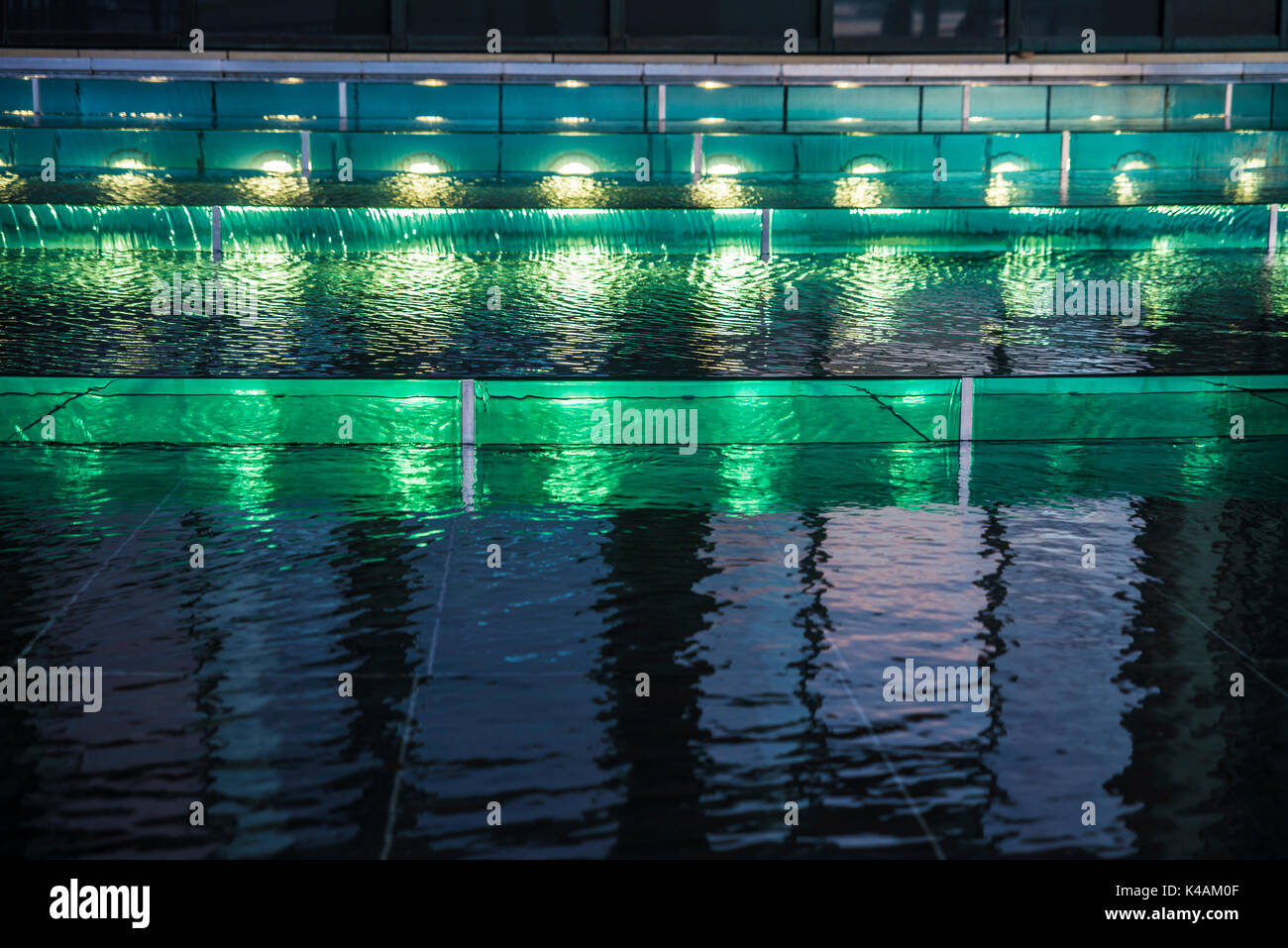 Green lights in motion in a fountain at night as abstract background ...
